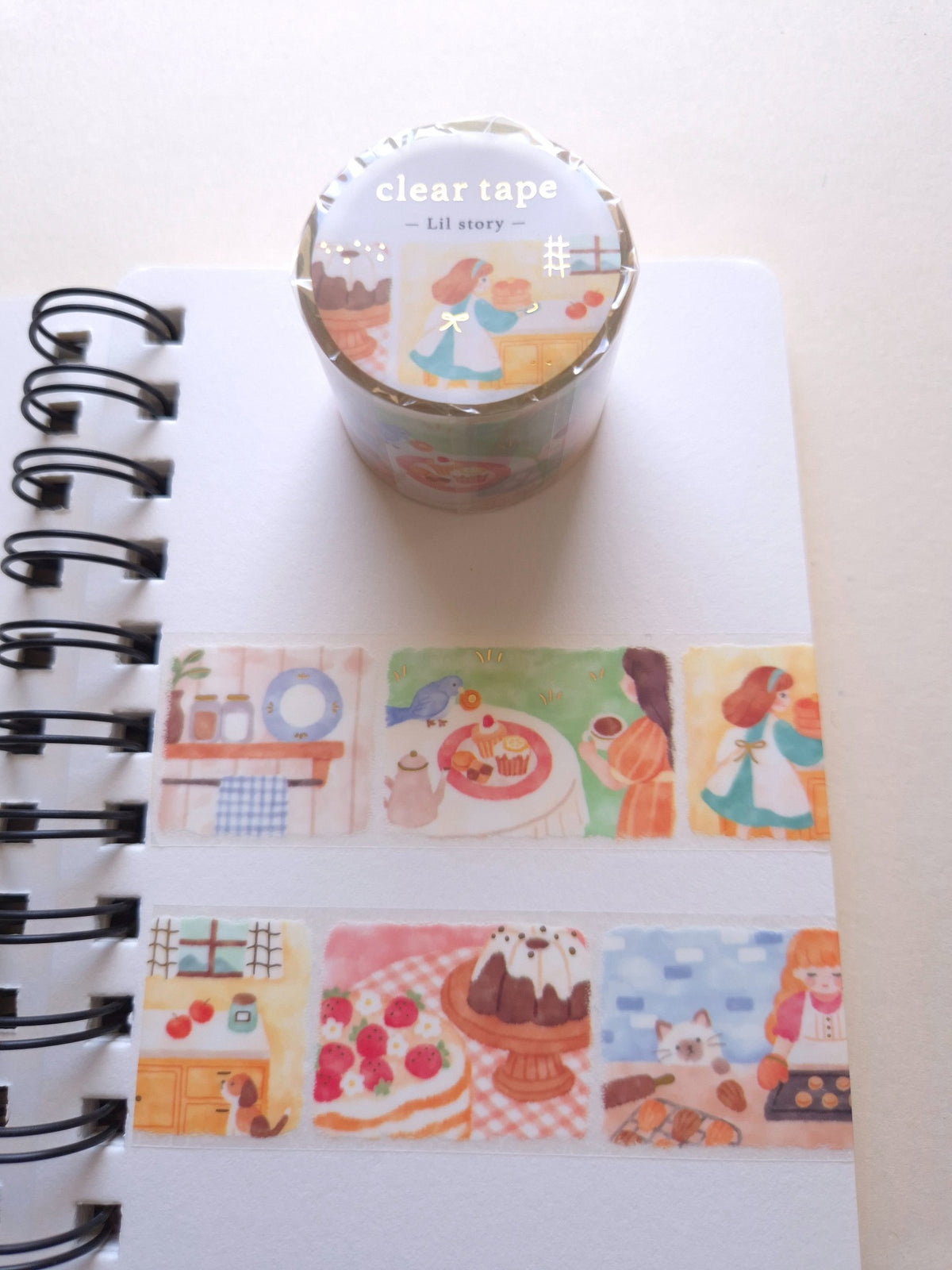 Mind Wave Lil Story Baking Scene foil-stamped clear tape roll with illustrated baking scenes applied in a spiral notebook