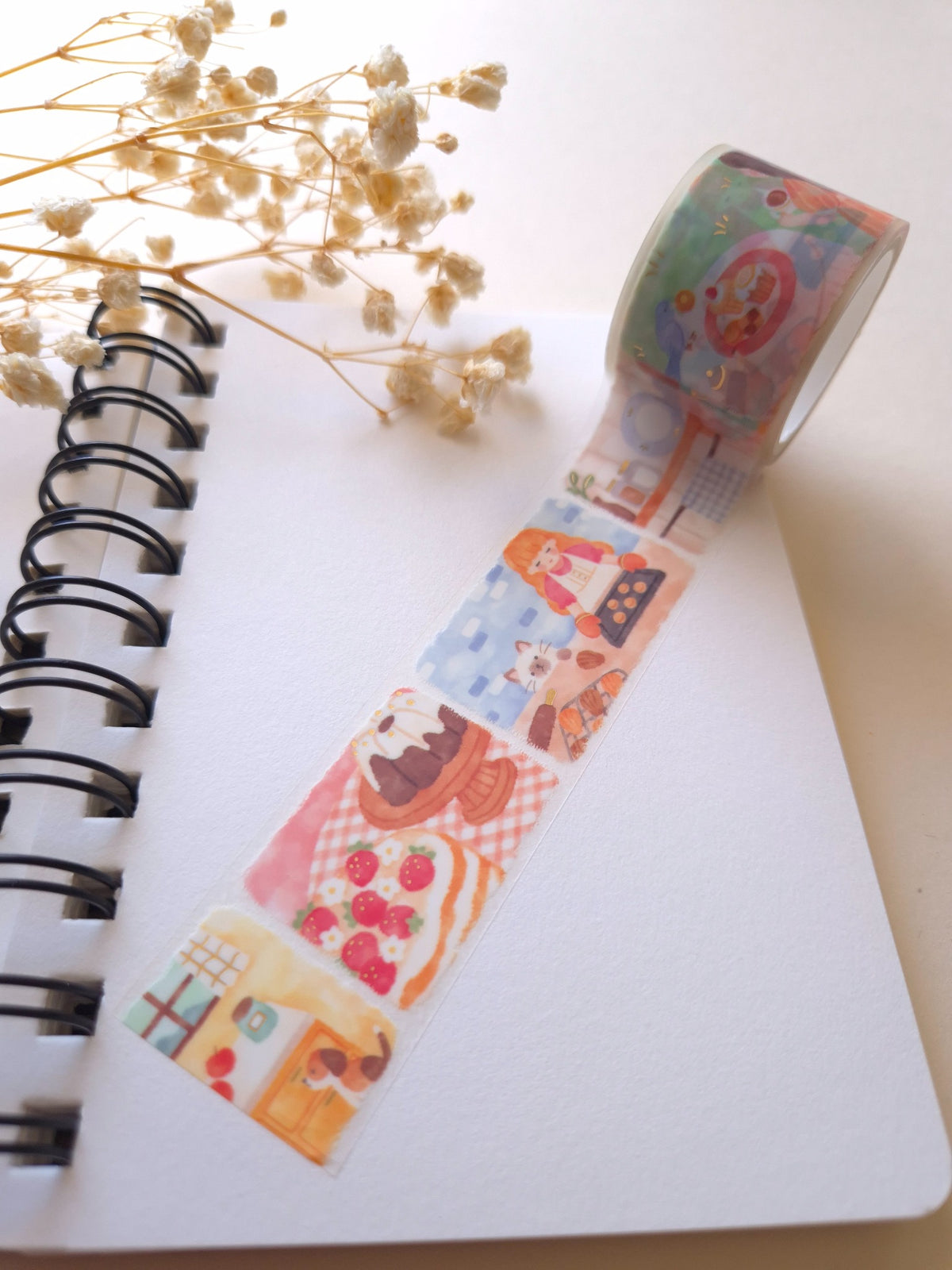 Mind Wave Lil Story Baking Scene clear tape unrolled across a spiral notebook with gold foil highlights and dried flowers